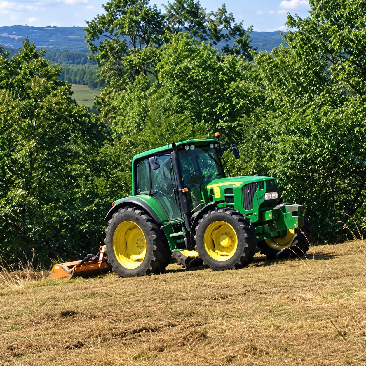 Un tracteur vert aux jantes jaunes équipé d'un broyeur travaille sur un terrain en pente entouré d'arbres.